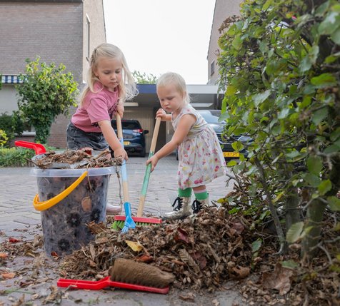 Kinderen ruimen bladeren
