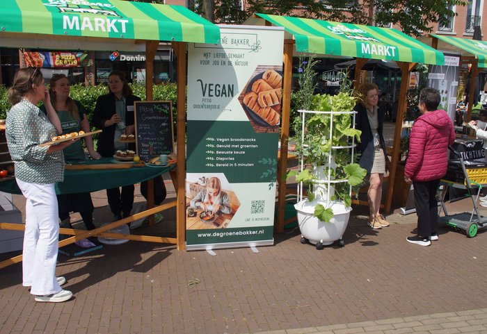 Een marktkraam met informatie over vegan eten